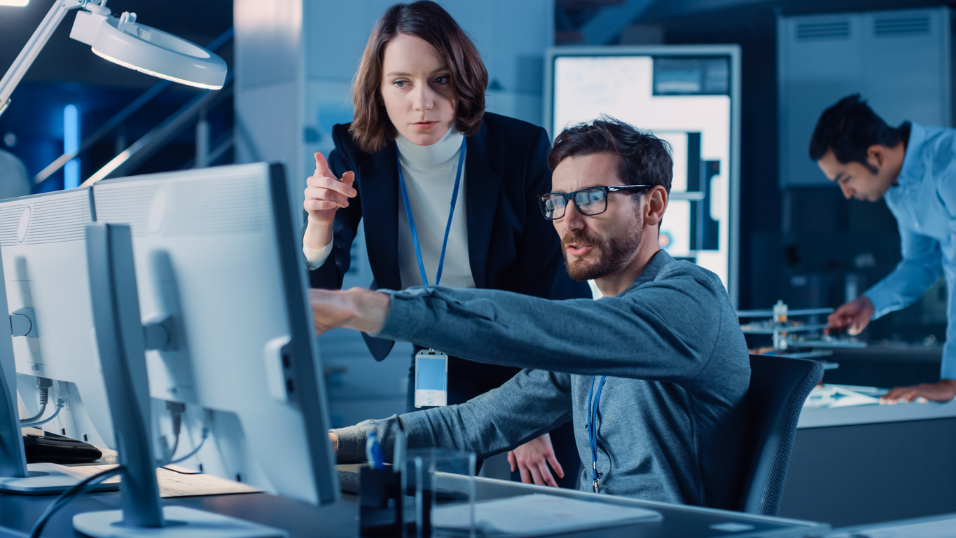 A cybersecurity manager discusses an issue with one of their team members.